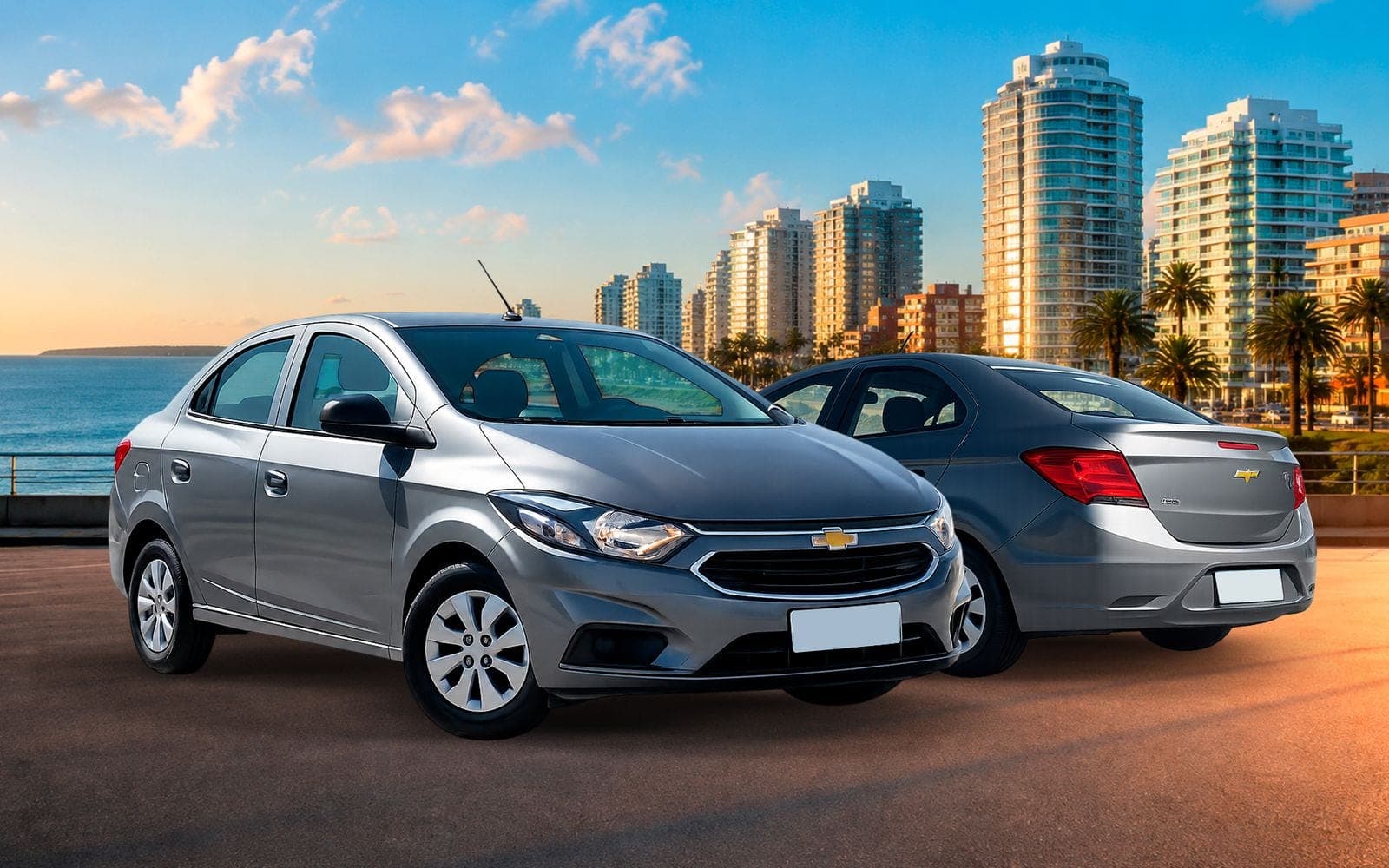 Chevrolet Prisma gris, de frente y de atrás, con la playa y los edificios de la costa de Montevideo detrás